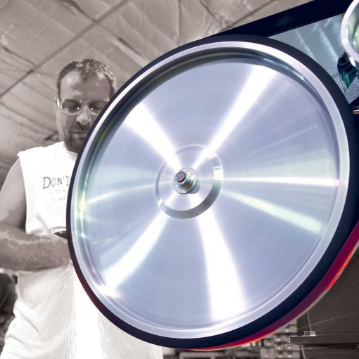Close up of man standing next to burr king belt grinder 20"