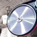 Close up of man standing next to burr king belt grinder 20"
