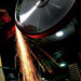 man grinding metal on burr king bba20 20" belt grinder with lots of sparks shootting to the ground