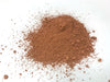 pile of reddish-brown cerium oxide polish on white background
