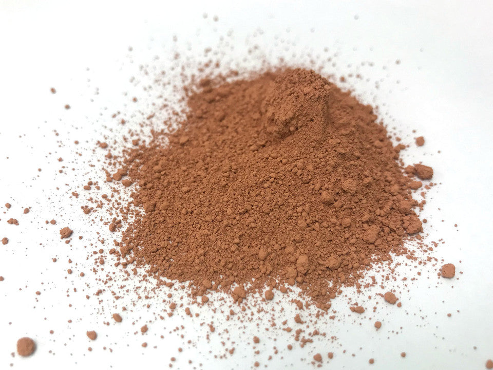pile of reddish-brown cerium oxide polish on white background
