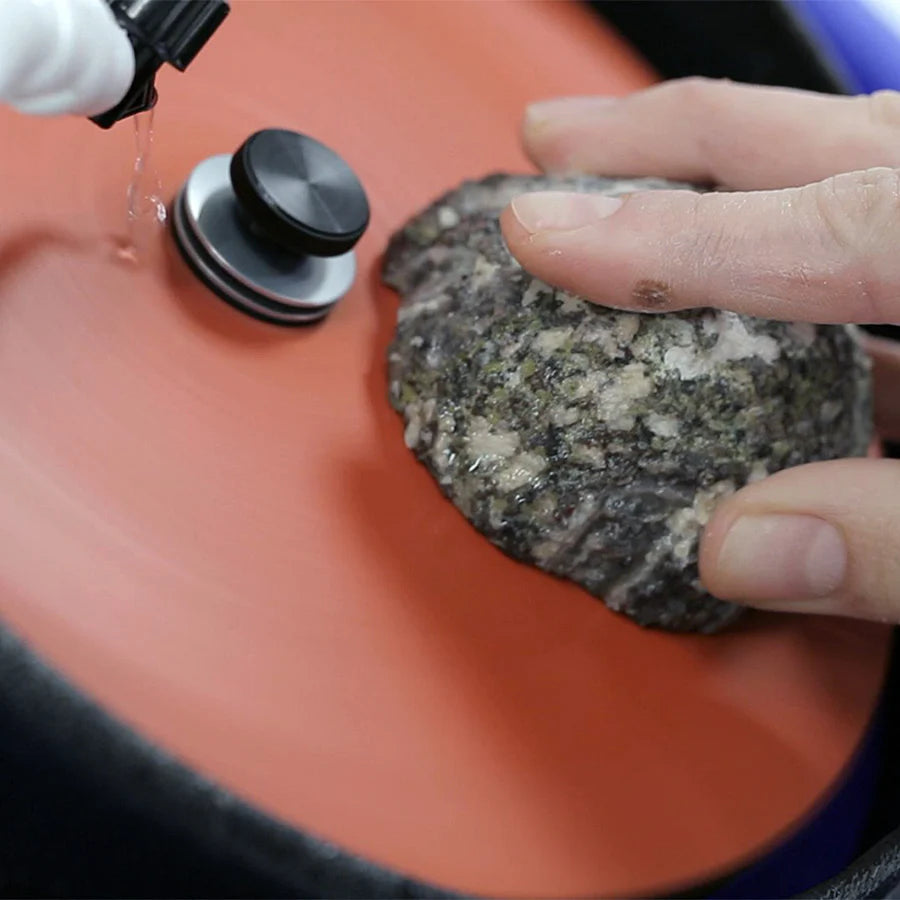 closeup of hand holding an agate rock to the hi tech diamond 8 slant cabber